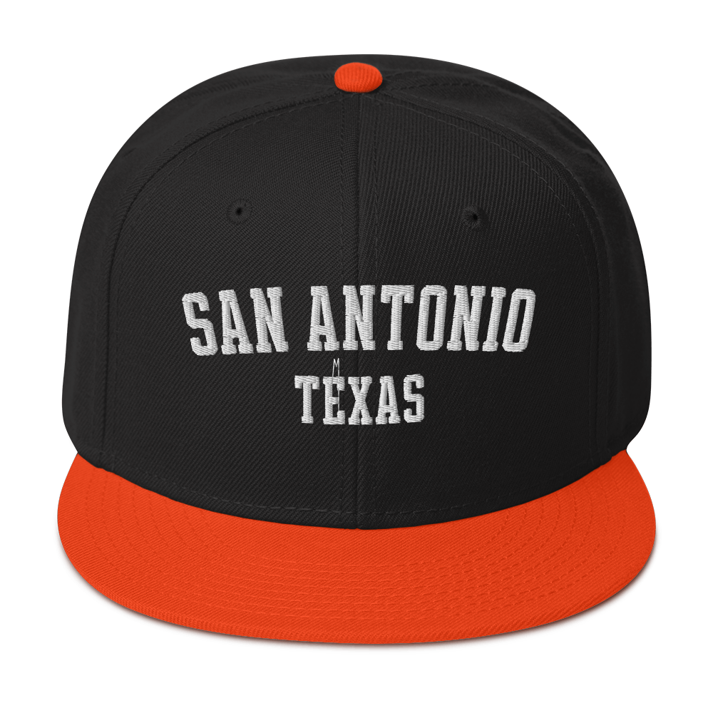 A black and orange snapback cap with the words "San Antonio, Texas".
