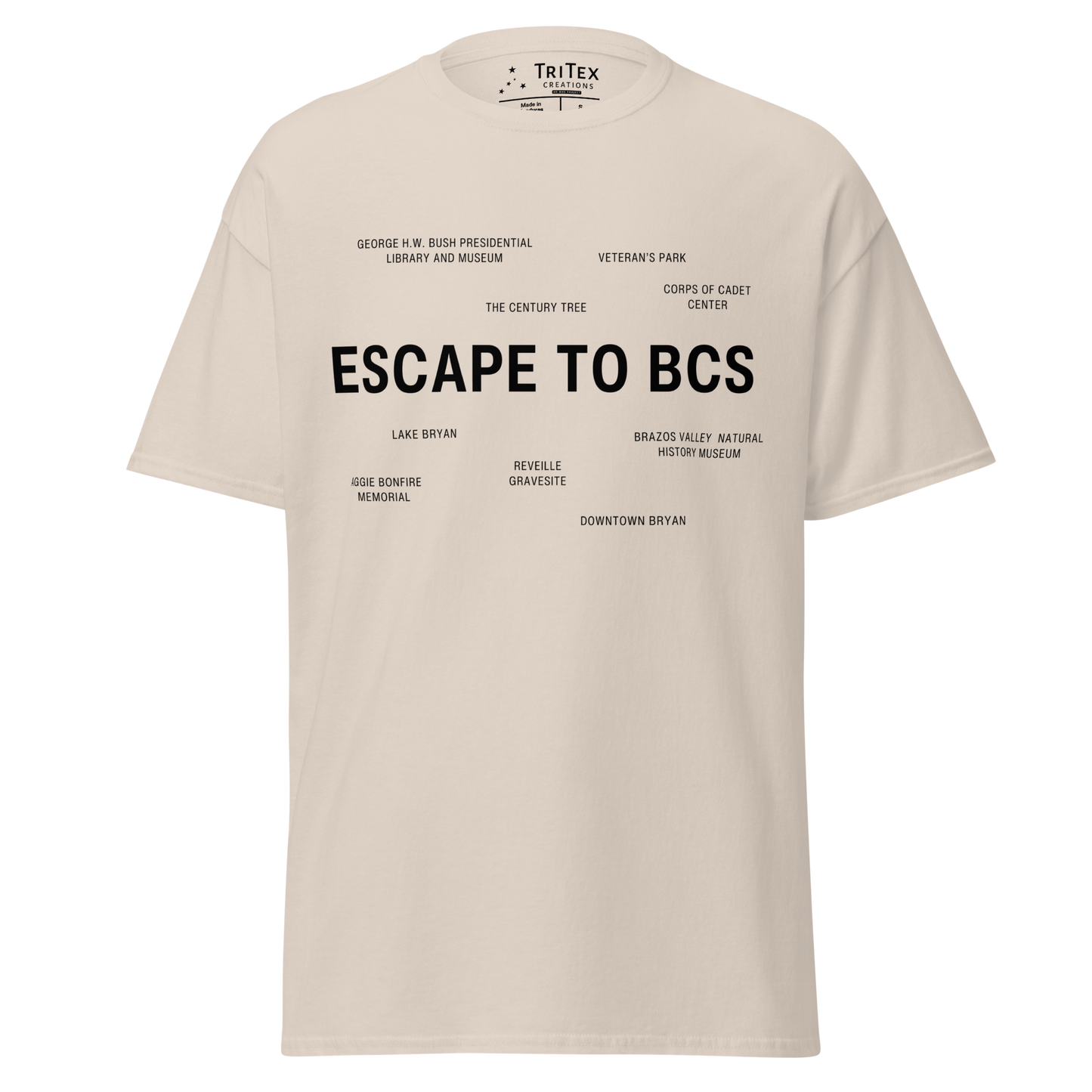 A natural-colored t-shirt which reads "Escape To BCS" in big, bold text with smaller text elements naming Bryan and College Station's landmarks.