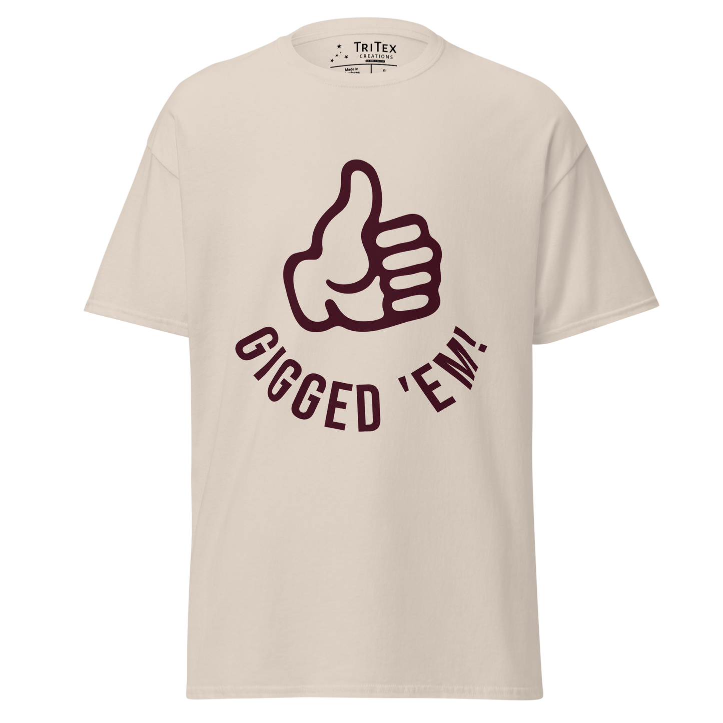 A natural-colored t-shirt featuring a left hand with it's thumb up and the text "Gigged 'em!".