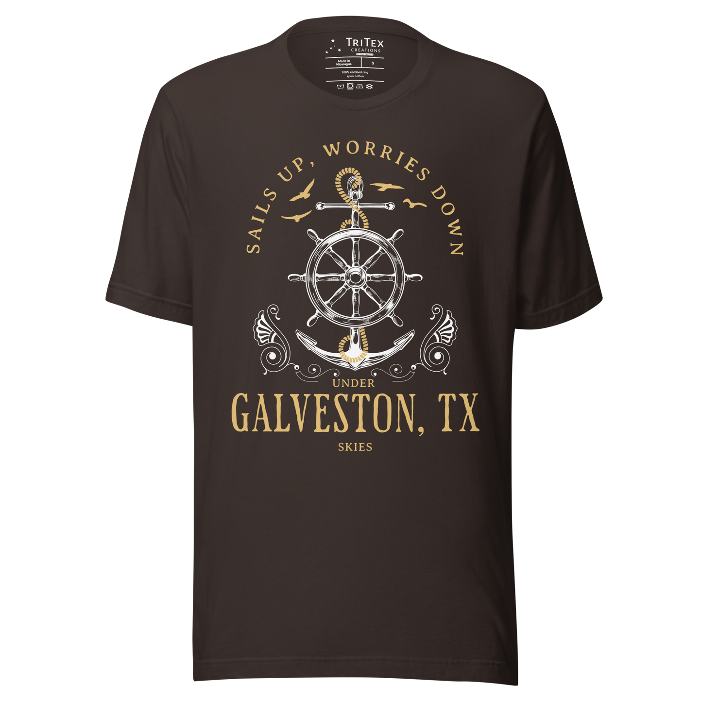 A brown t-shirt featuring an anchor and seagulls with the words "Sails up, worries down under Galveston, TX skies".