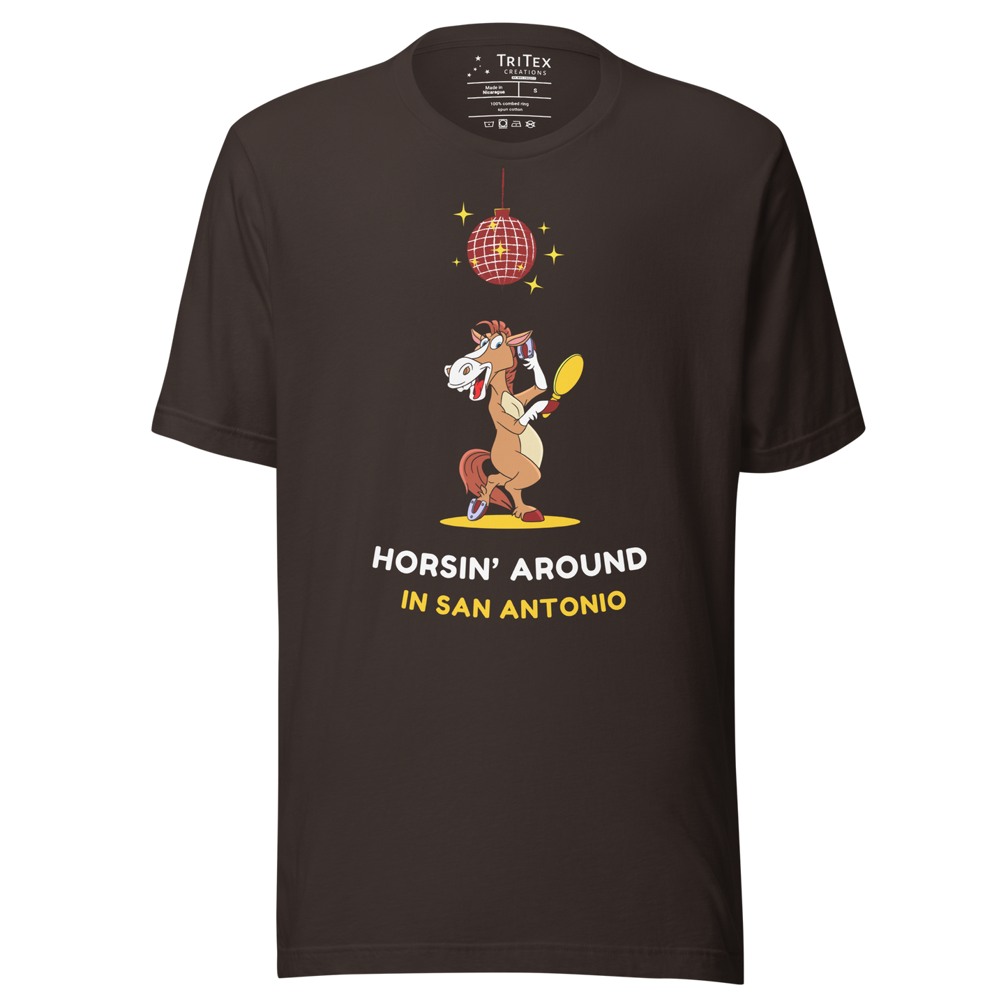 A brown t-shirt featuring an image of a cartoon horse primping under a sparkling disco ball with the words "Horsin' around in San Antonio".