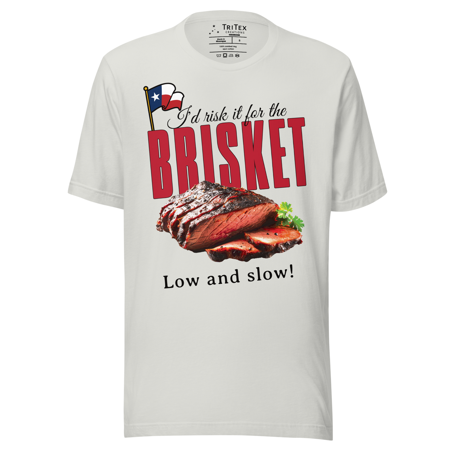 A silver t-shirt featuring a cooked brisket with the words "I'd risk it for the brisket. Low and slow!".