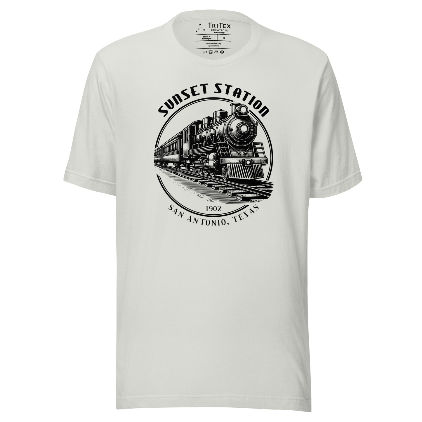 A silver t-shirt featuring a vintage locomotive with the words "Sunset Station. 1902. San Antonio, Texas".