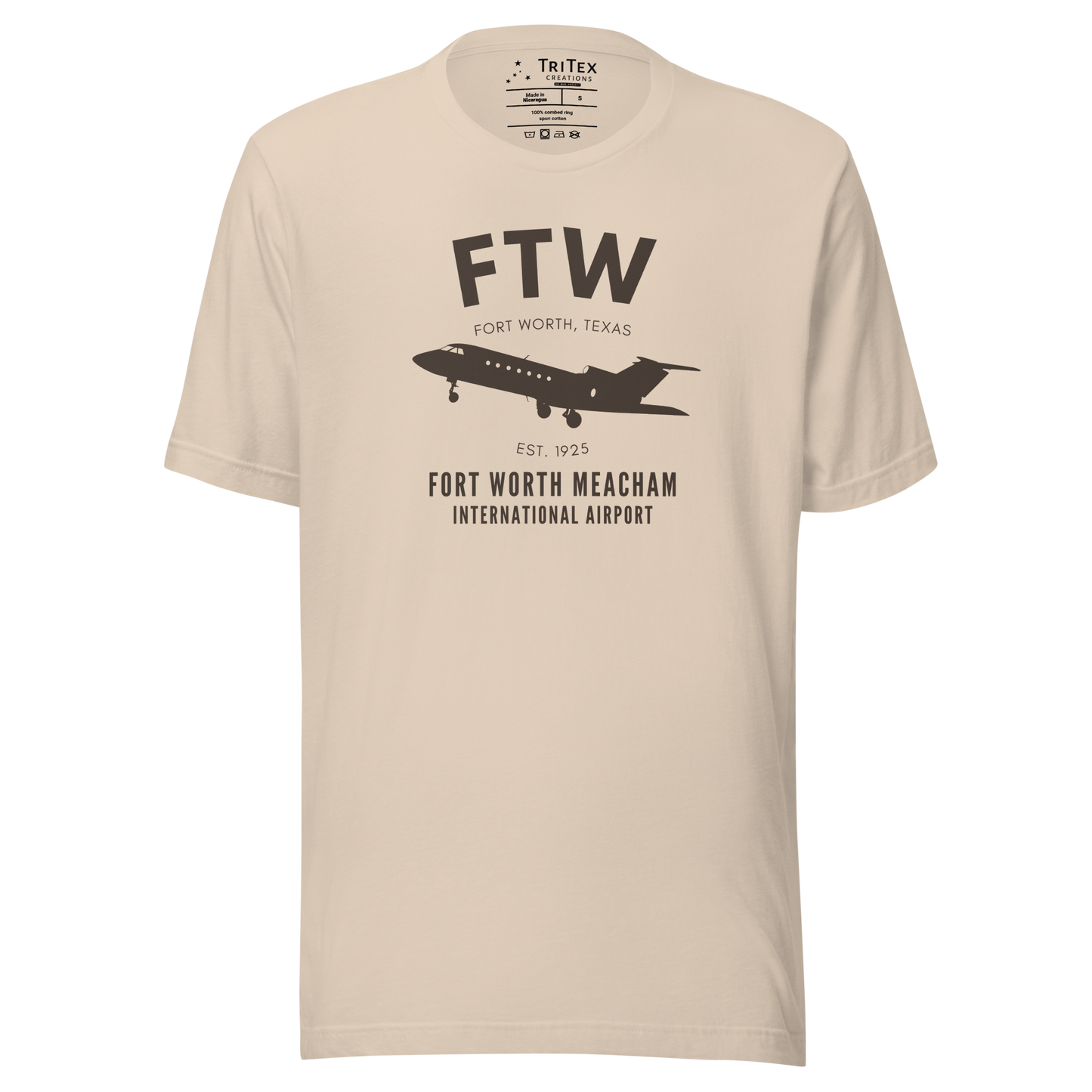 A soft cream t-shirt featuring a small jet and the text "FTW Fort Worth, Texas. Est. 1925. Fort-Worth Meacham International Airport".
