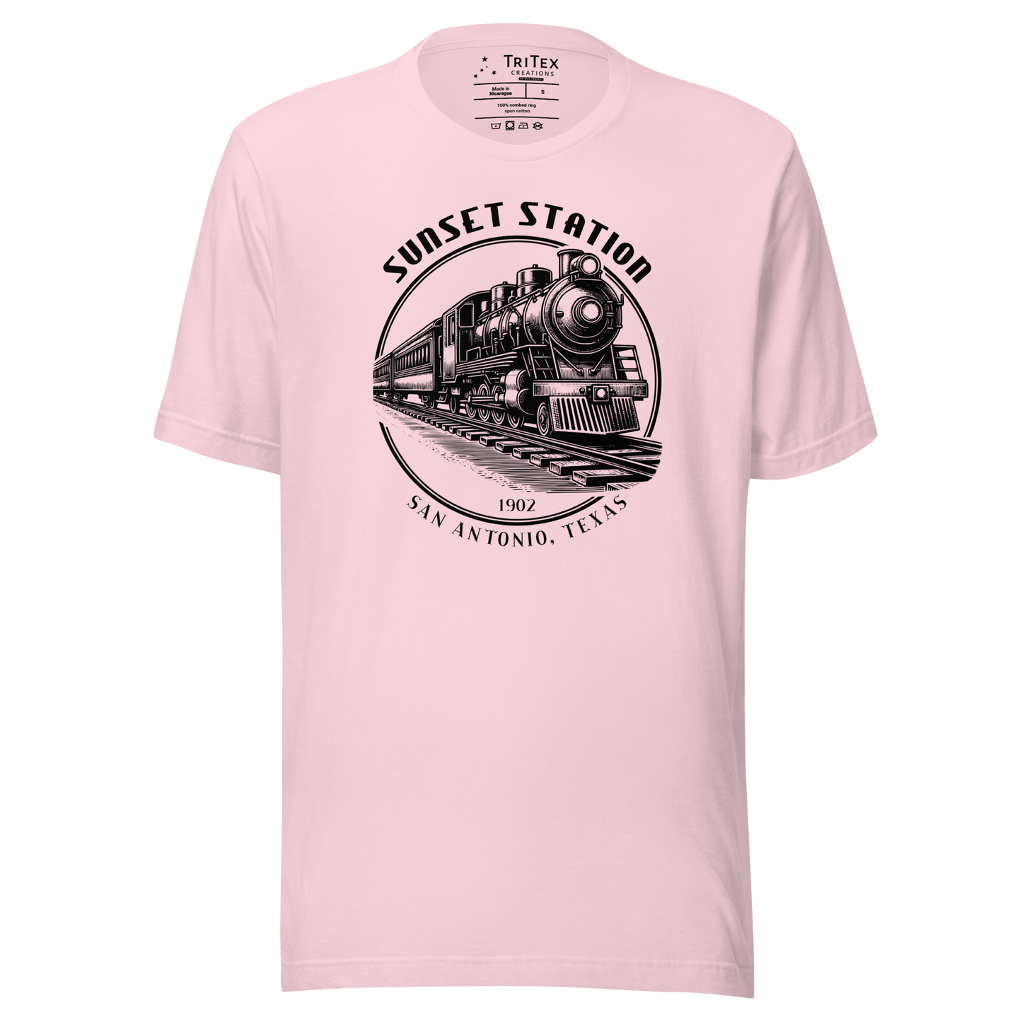 A soft pink t-shirt featuring a vintage locomotive with the words "Sunset Station. 1902. San Antonio, Texas".