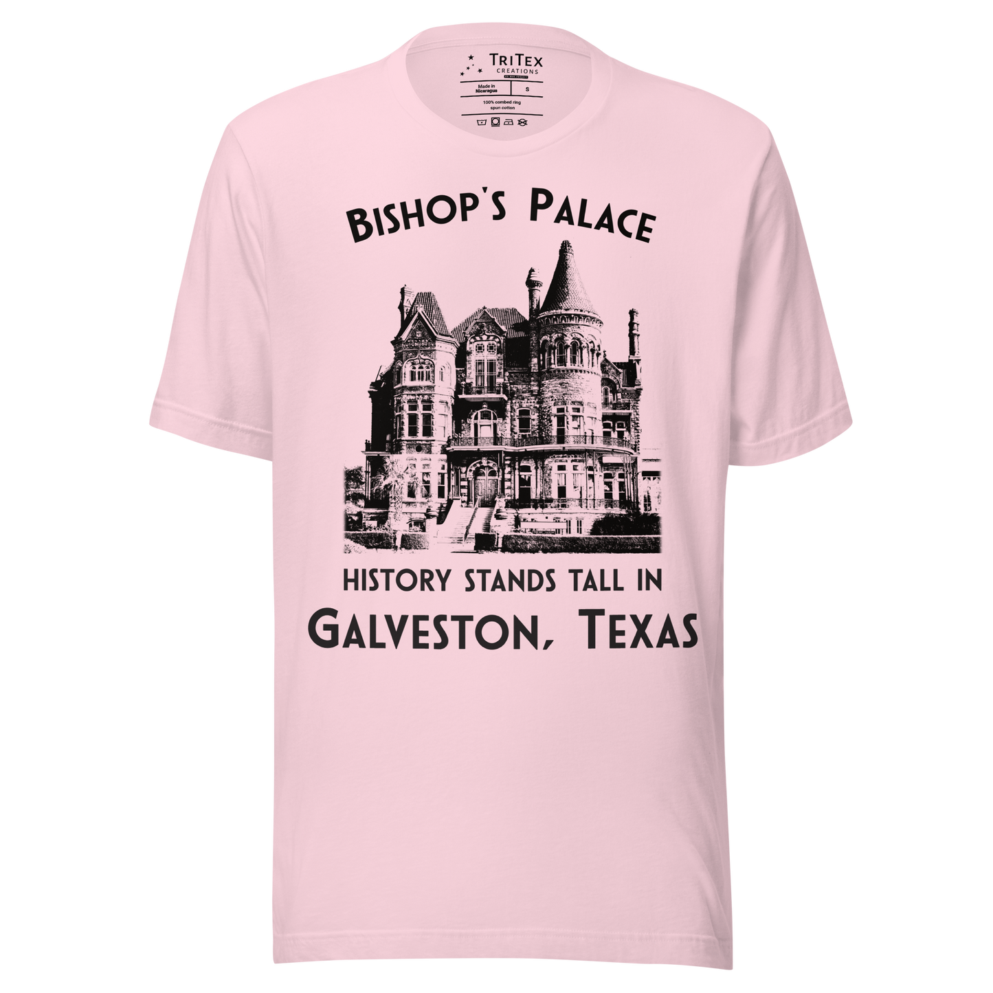 A soft pink t-shirt featuring a vintage-style picture of Bishop's Palace with the text "Bishop's Palace. History stands tall in Galveston, Texas".