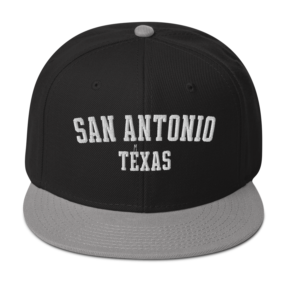 A black and gray snapback cap with the words "San Antonio, Texas".
