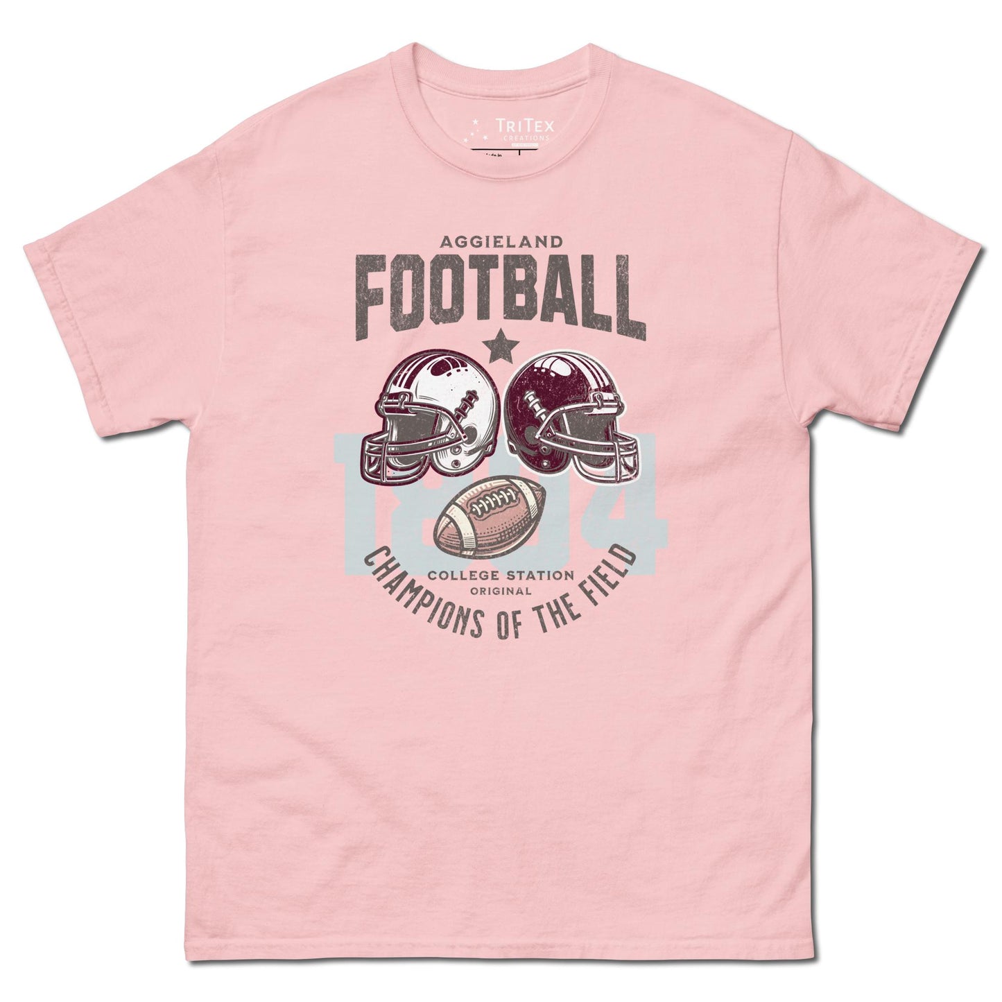 A light pink t-shirt featuring football helmets and a football with the text "Aggieland Football College Station original Champions of the field"