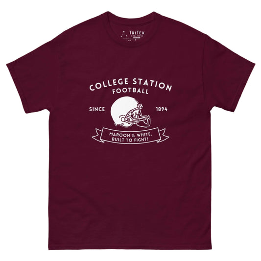 A maroon shirt with the text "College Station football since 1894 Maroon & White, Built to fight!" featuring an image of a football helmet.