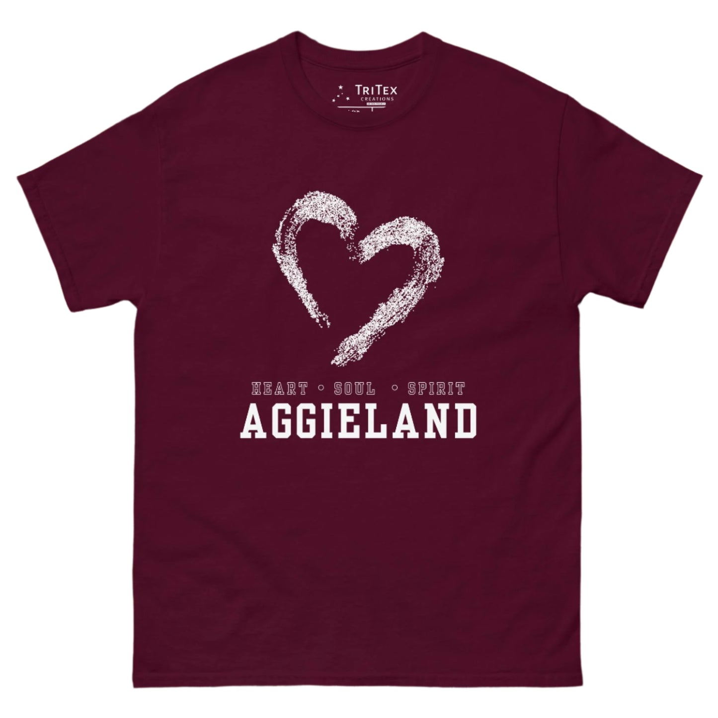 A maroon t-shirt featuring the outline of a hear with the words "Heart • Soul • Spirit Aggieland"