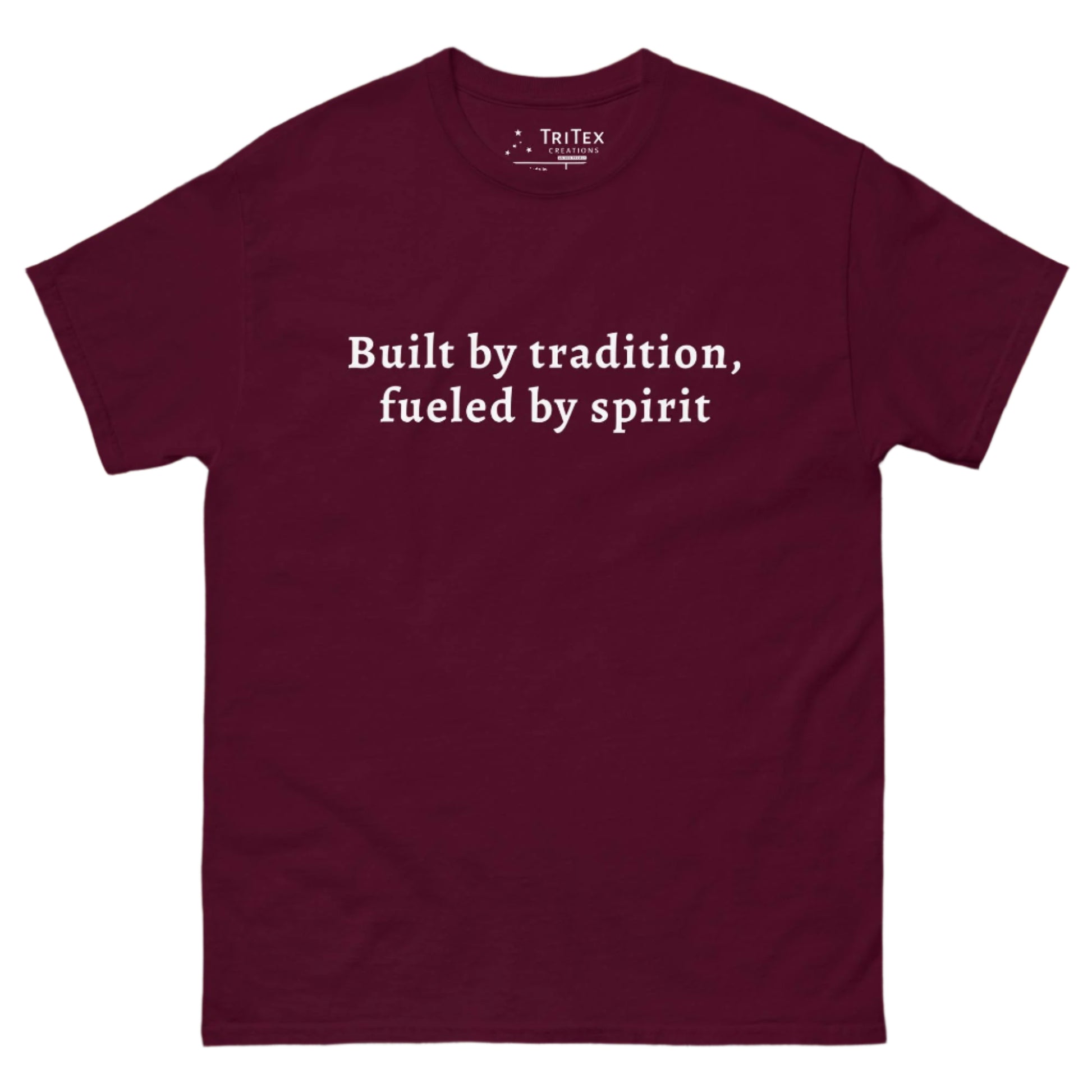 A maroon t-shirt that reads "built by tradition, fueled by spirit".