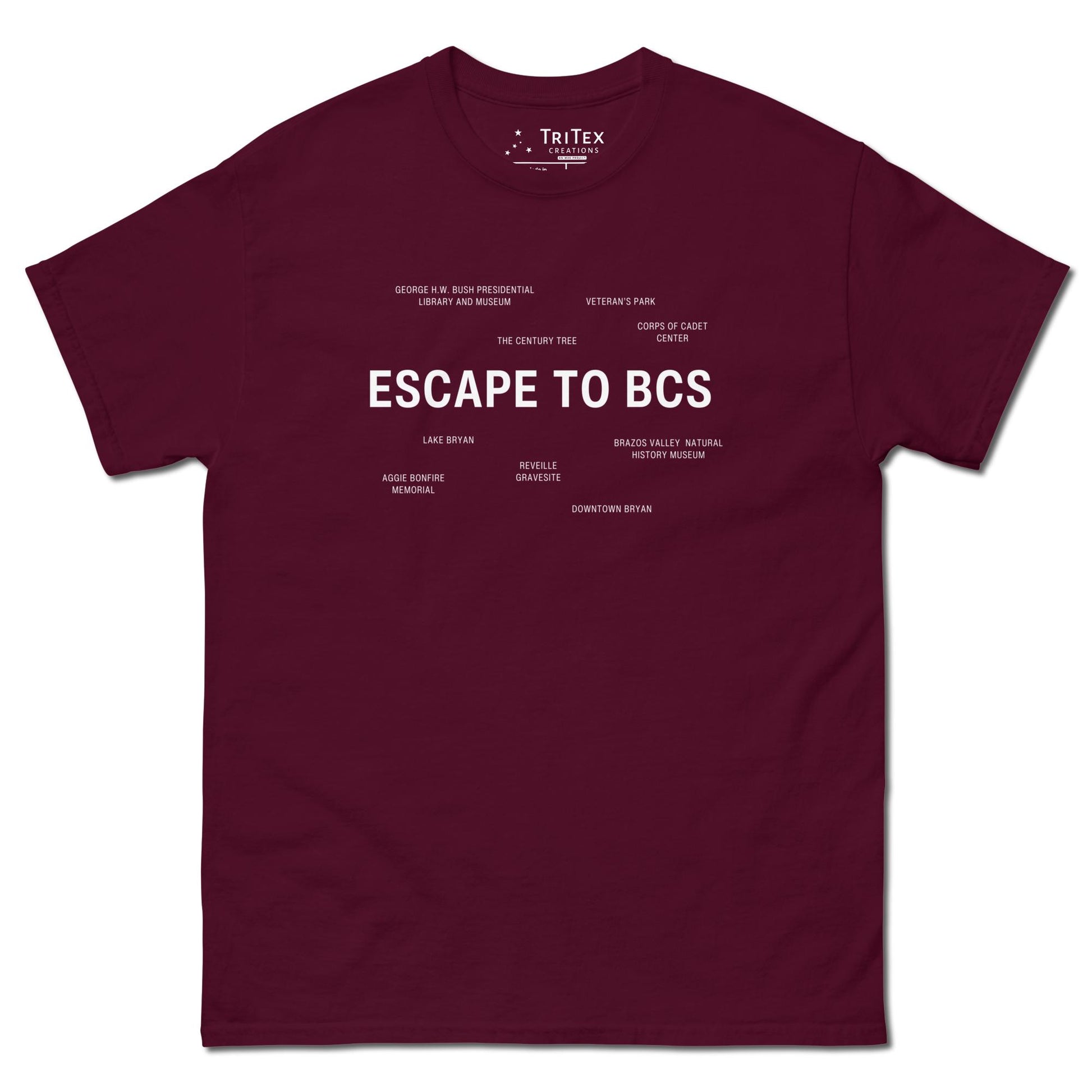 A maroon t-shirt which reads "Escape To BCS" in big, bold text with smaller text elements naming Bryan and College Station's landmarks.