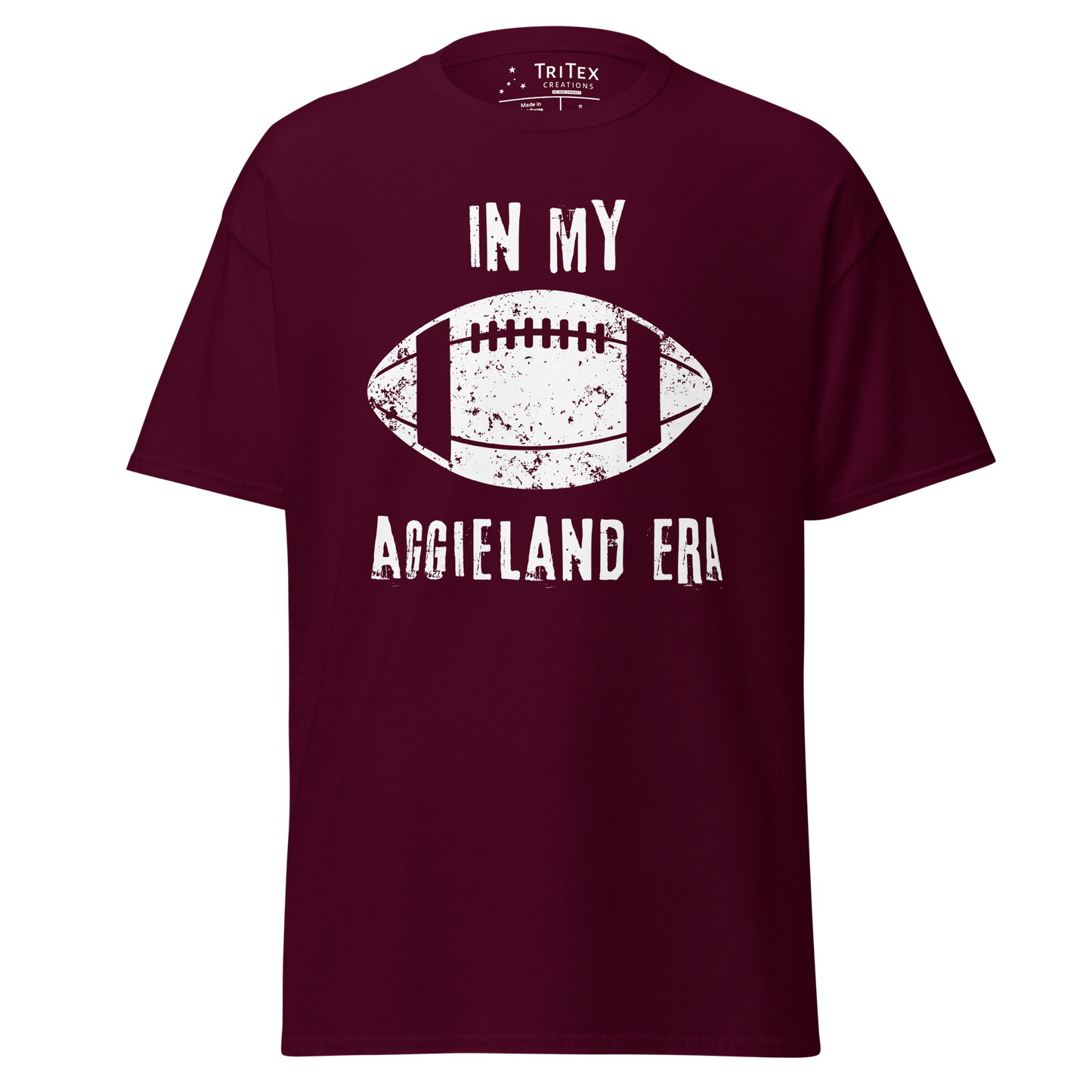 A maroon t-shirt featuring a silhouette of a football with the words "In my Aggieland era".