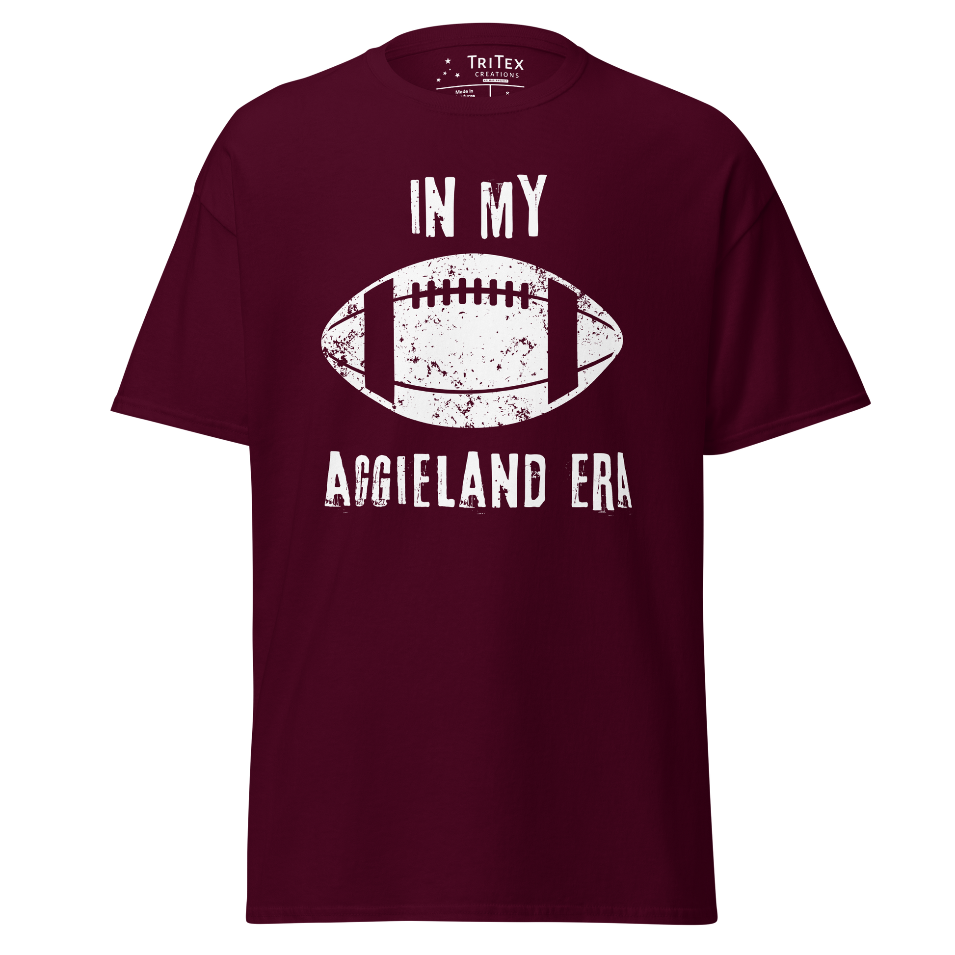 A maroon t-shirt featuring a silhouette of a football with the words "In my Aggieland era".