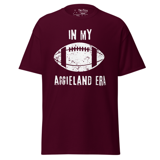 A maroon t-shirt featuring a silhouette of a football with the words "In my Aggieland era".