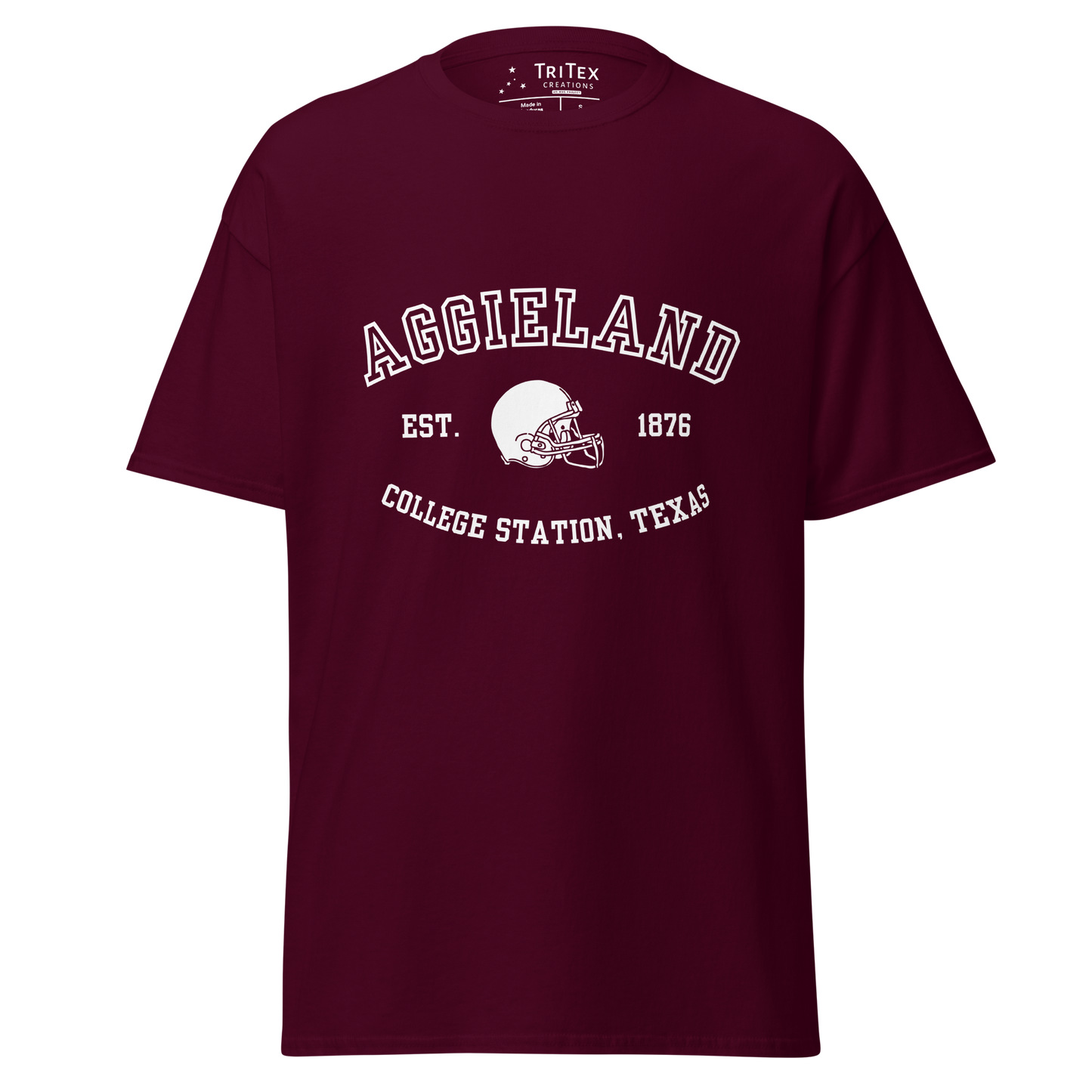 A maroon t-shirt featuring a graphic image of a football helmet with the words "Aggieland Est. 1876 College Station, Texas".
