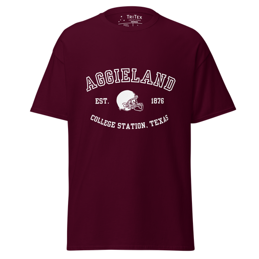 A maroon t-shirt featuring a graphic image of a football helmet with the words "Aggieland Est. 1876 College Station, Texas".