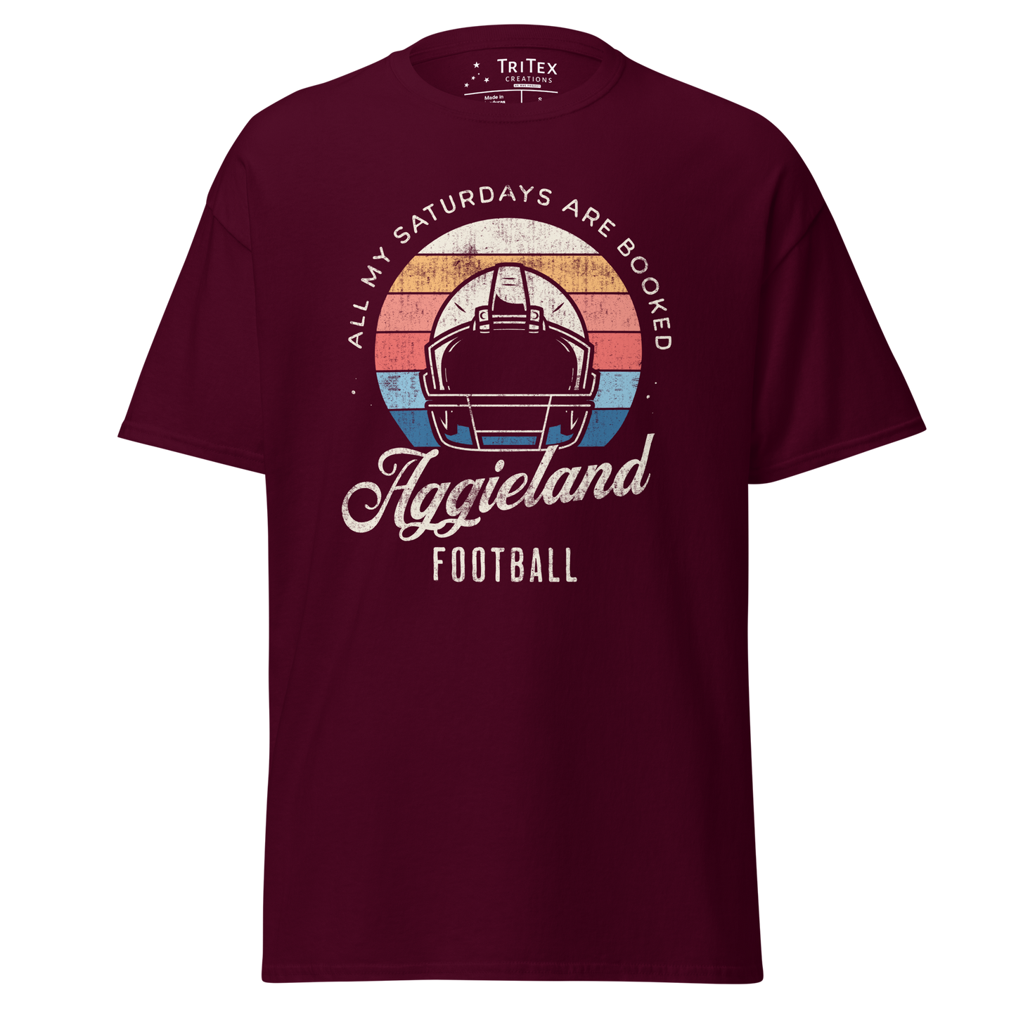 A maroon t-shirt featuring a football helmet and the words "All my Saturdays are booked Aggieland Football".