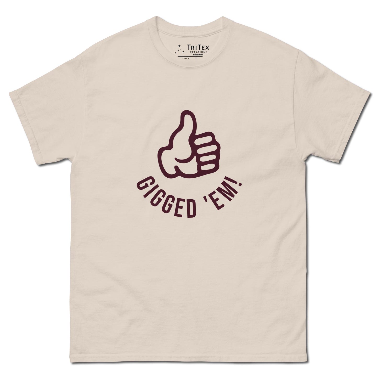 A natural-colored t-shirt featuring a left hand with it's thumb up and the text "Gigged 'em!".