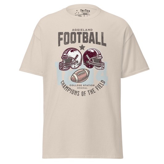 A natural-colored t-shirt featuring football helmets and a football with the text "Aggieland Football College Station original Champions of the field"