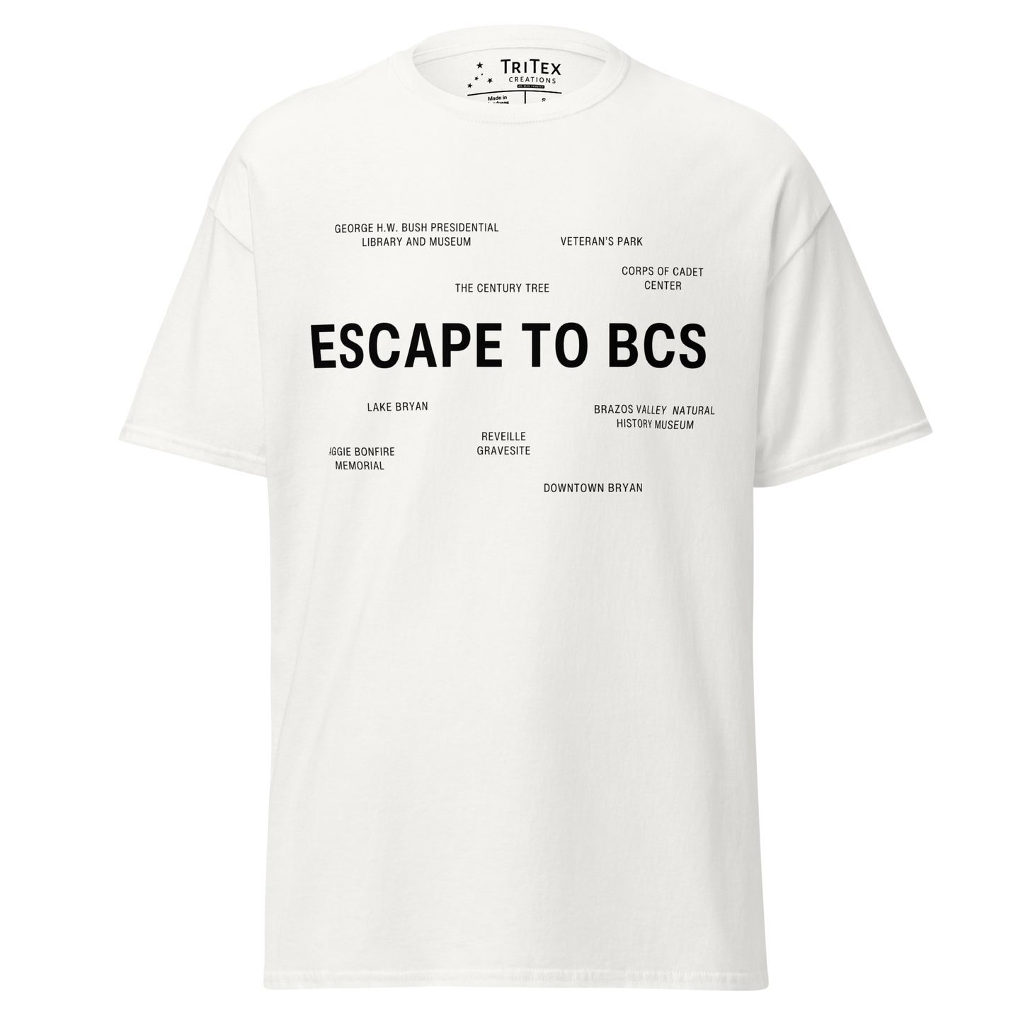 A white t-shirt which reads "Escape To BCS" in big, bold text with smaller text elements naming Bryan and College Station's landmarks.