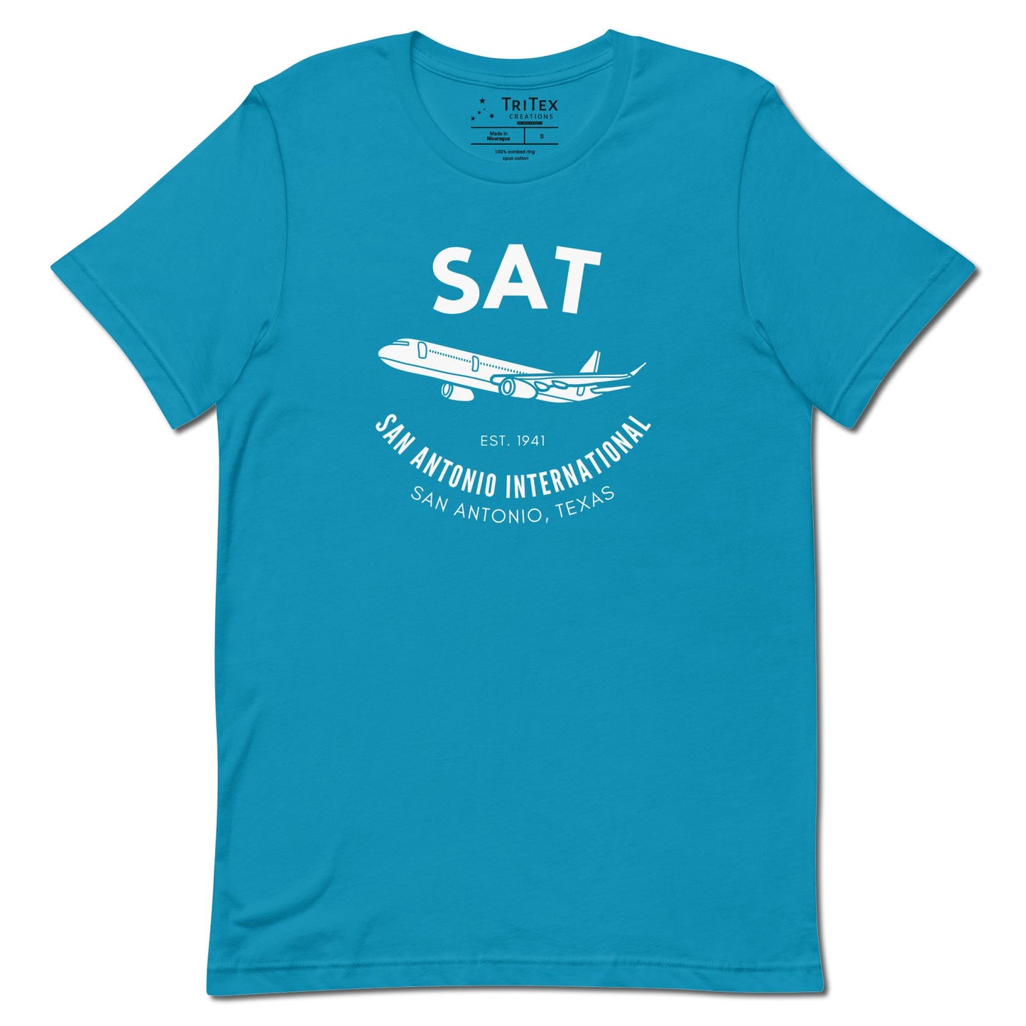 An aqua blue t-shirt featuring a silhouette of a passenger plane with the text "SAT. Est. 1941. San Antonio International. San Antonio, Texas".