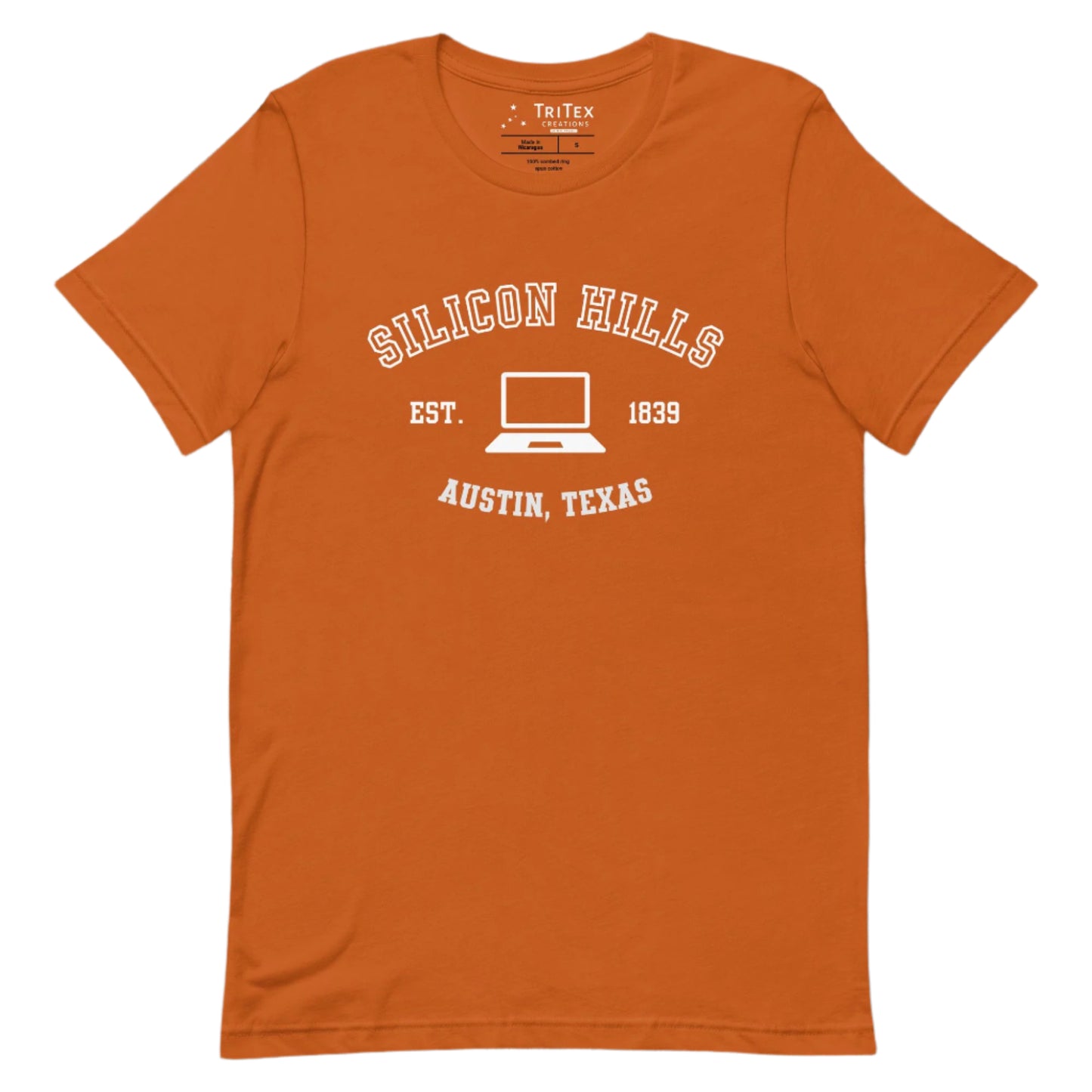 An autumn-colored t-shirt featuring a graphic image of a laptop with the words "Silicon Hills Est. 1839 Austin, Texas".