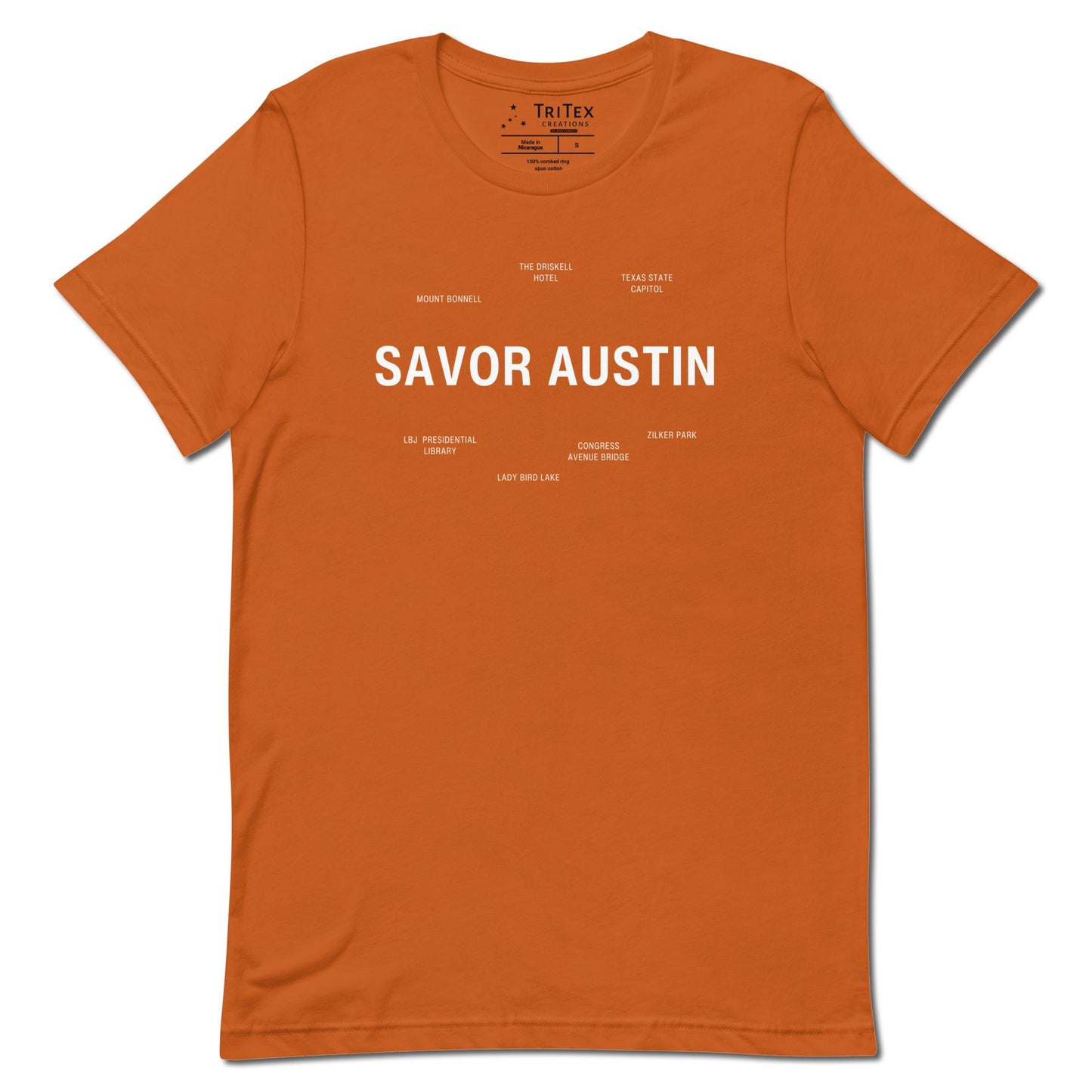 An autumn-colored t-shirt which reads "Savor Austin" in big, bold text with smaller text elements naming Austin's landmarks.