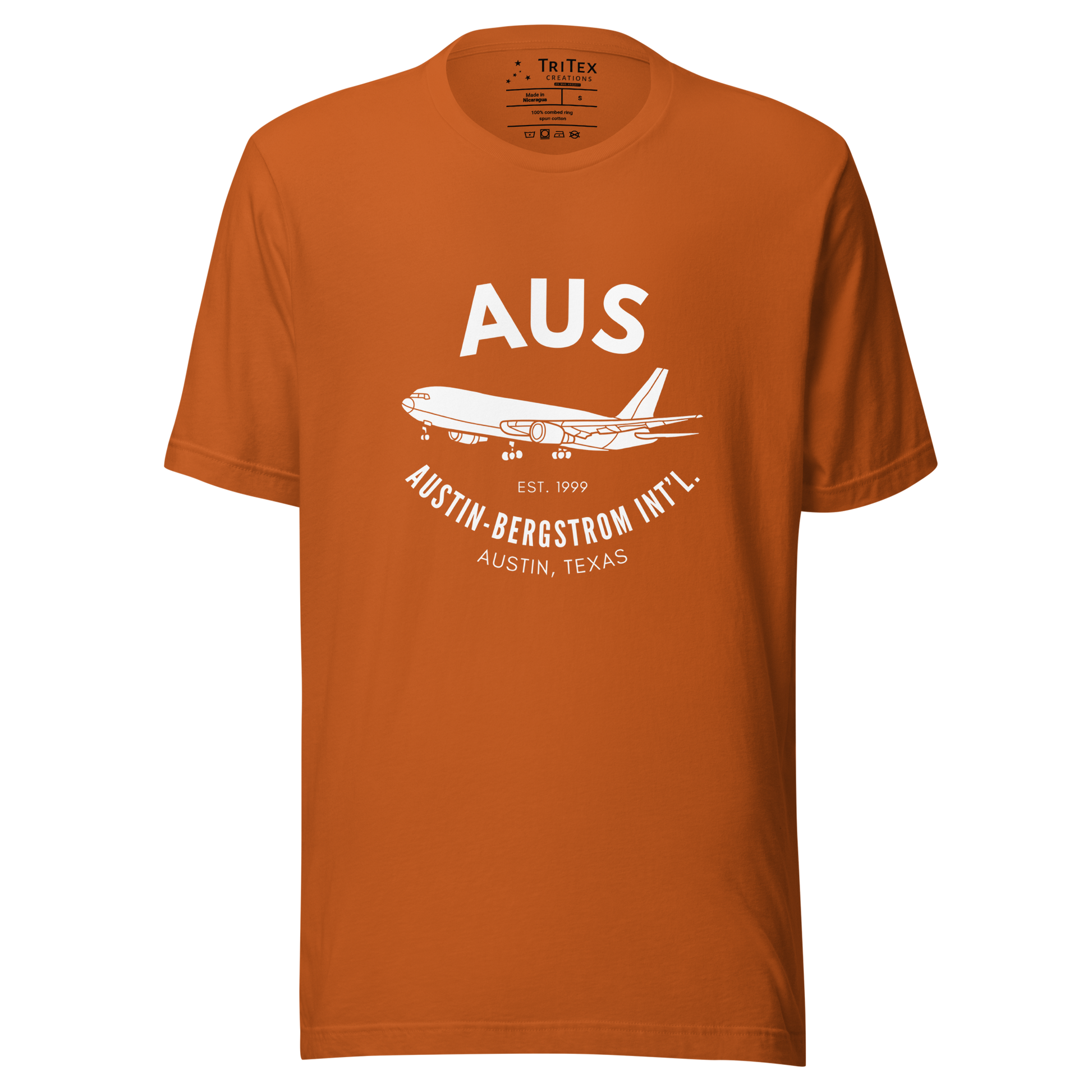 An autumn-colored t-shirt with a silhouette of a passenger plane with the text "AUS Est. 1999 Austin-Bergstrom Int'l. Austin, Texas".