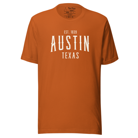 An autumn-colored t-shirt with the words "Austin Texas Est. 1839".
