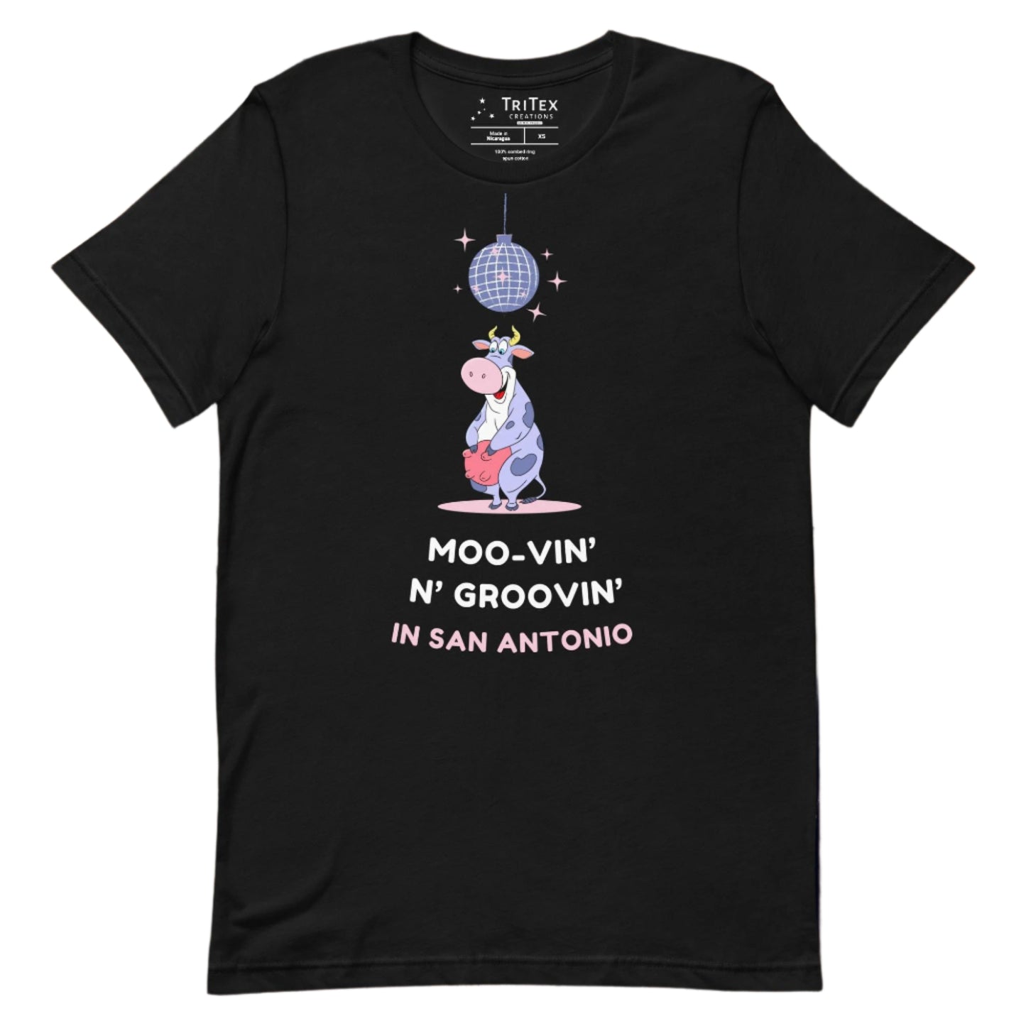 A black t-shirt with a cartoon cow standing under a sparkling disco ball with the the text "Moo-vin' n' groovin' in San Antonio".