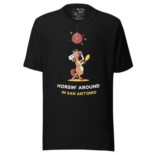 A black t-shirt featuring an image of a cartoon horse primping under a sparkling disco ball with the words "Horsin' around in San Antonio".