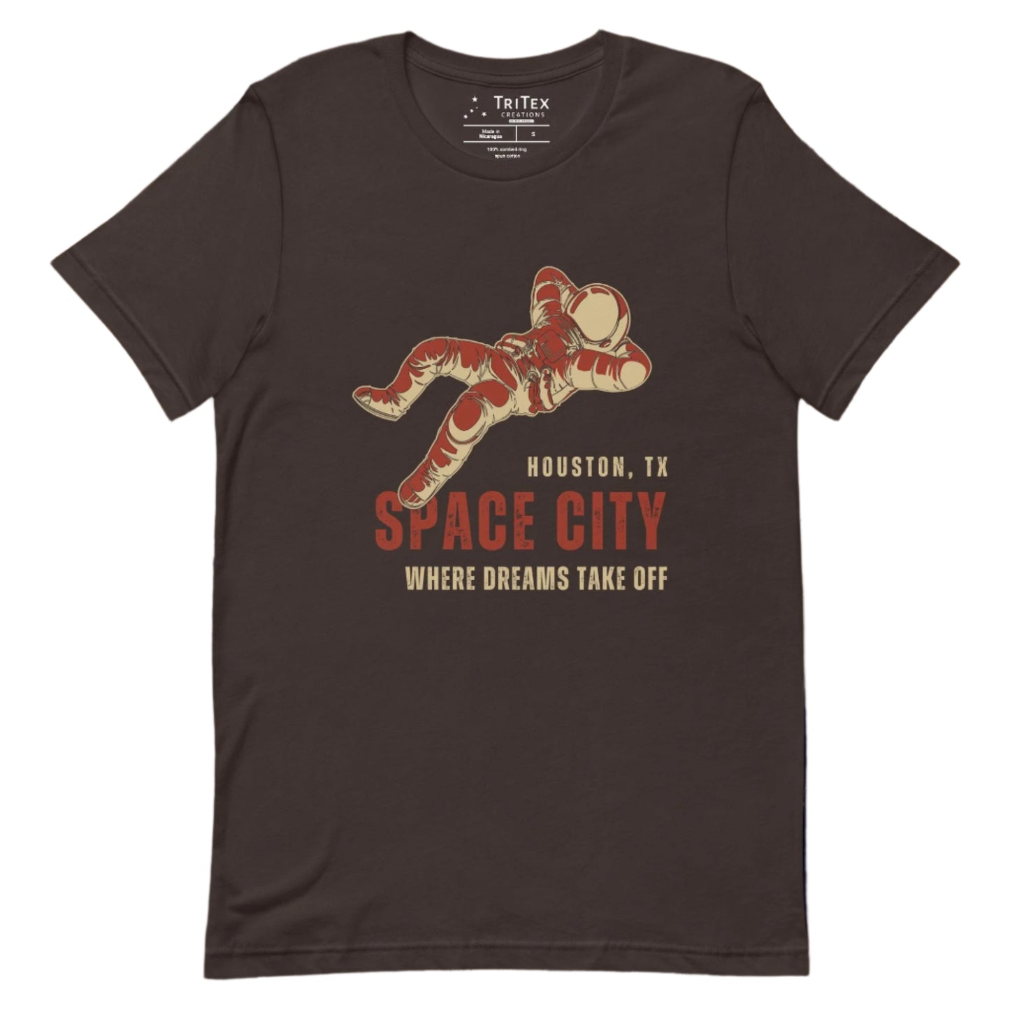 A brown t-shirt featuring a dreaming astronaut with the words "Houston, TX. Space city. Where dreams come true".