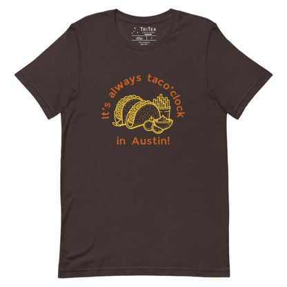 A brown t-shirt featuring a taco meal with french fries and guacomole with the text "It's always taco'clock in Austin!".