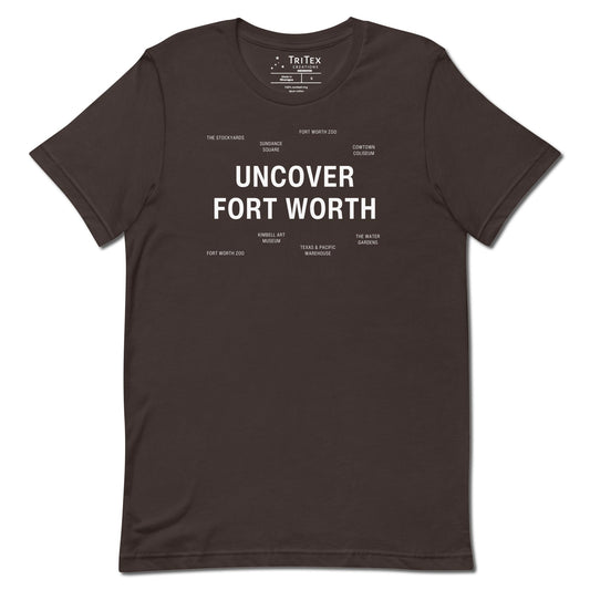 A brown t-shirt which reads "Uncover Fort Worth" in big, bold text with smaller text elements naming Fort Worth landmarks.