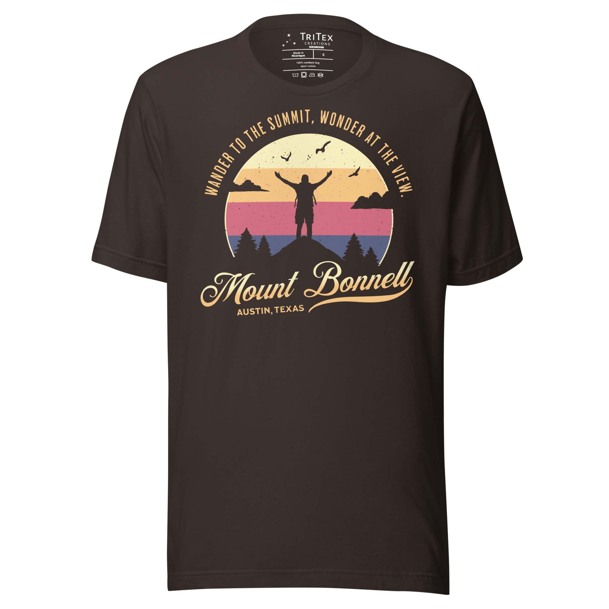 A brown t-shirt featuring the silhouette of a person standing on a mountain with the words "Wander to the summit, wonder at the view."