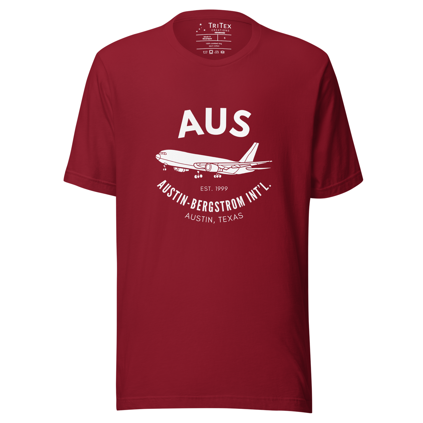 A cardinal red t-shirt with a silhouette of a passenger plane with the text "AUS Est. 1999 Austin-Bergstrom Int'l. Austin, Texas".