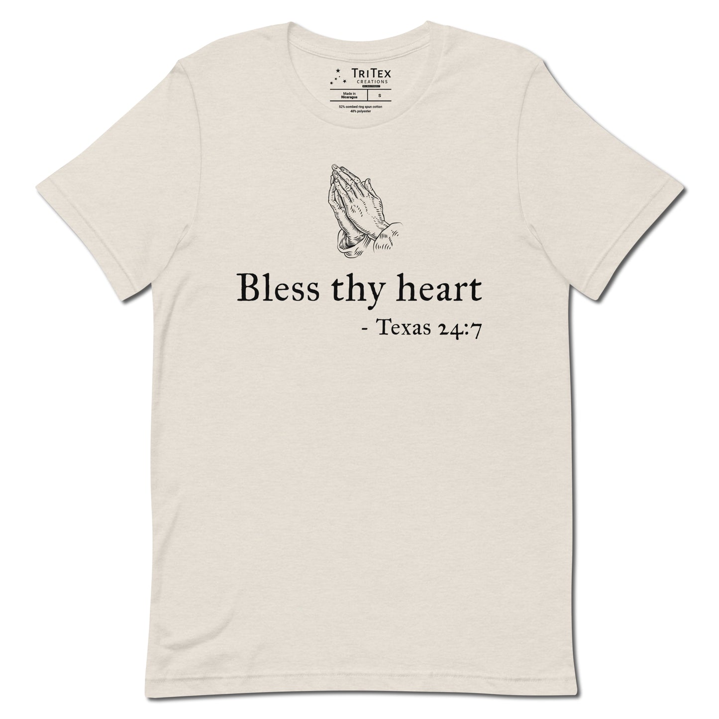 A heather dust t-shirt featuring a vintage illustration of hands clasped in prayer with the words "Bless thy heart - Texas 24:7"