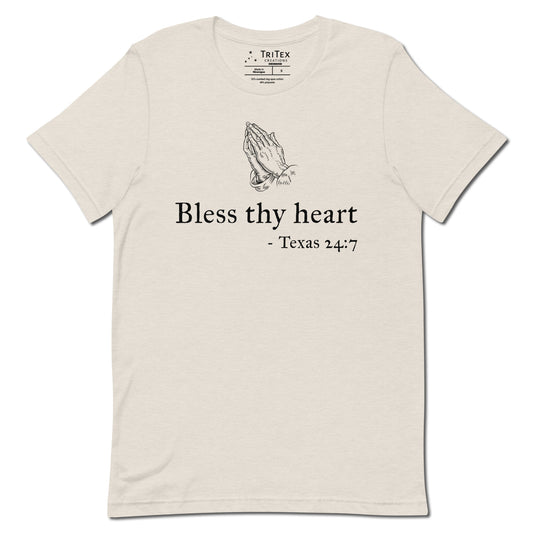 A heather dust t-shirt featuring a vintage illustration of hands clasped in prayer with the words "Bless thy heart - Texas 24:7"