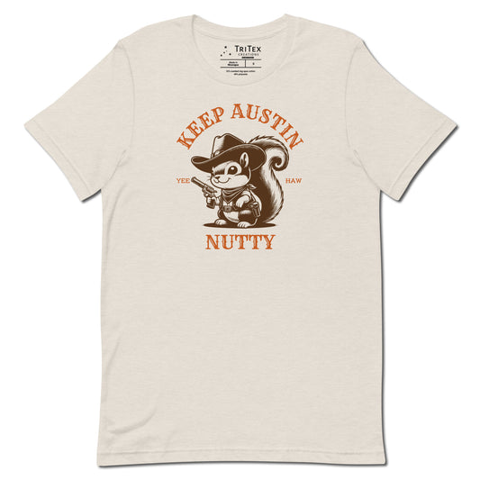 A heather dust t-shirt featuring a vintage illustration of a squirrel dressed like a cowboy with text that reads "Keep Austin Nutty. Yee Haw".