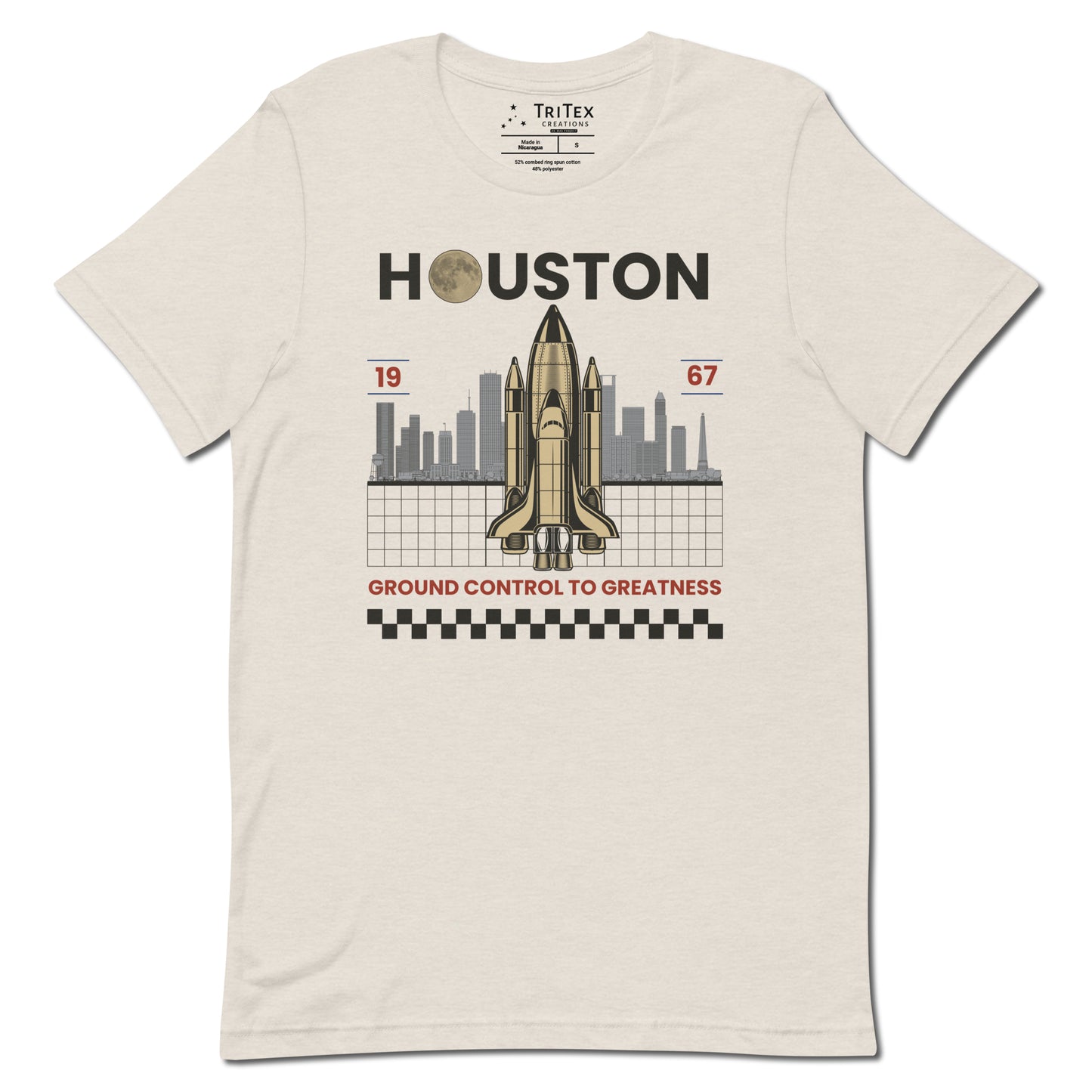 A heather dust t-shirt featuring a space shuttle in front of the Houston skyline and the text "Houston 1967 Ground control to greatness".