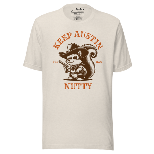 A heather dust t-shirt featuring a vintage illustration of a squirrel dressed like a cowboy with text that reads "Keep Austin Nutty. Yee Haw".