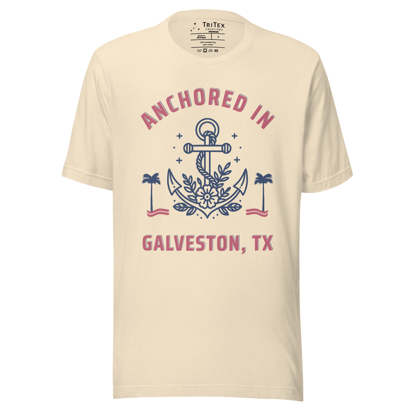 A heather natural t-shirt featuring an image of an anchor, palm trees and a flower with the text "Anchored in Galveston, TX".