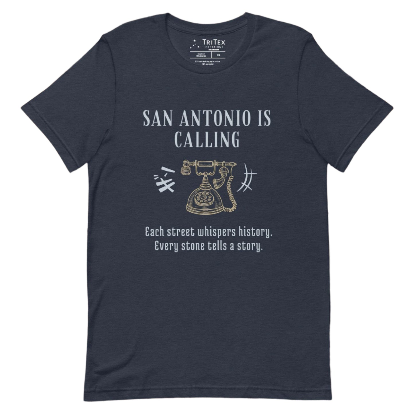 A heather navy t-shirt featuring a graphic image of a vintage rotary phone with the text "San Antonio is calling. Each street whispers history. Every stone tells a story."