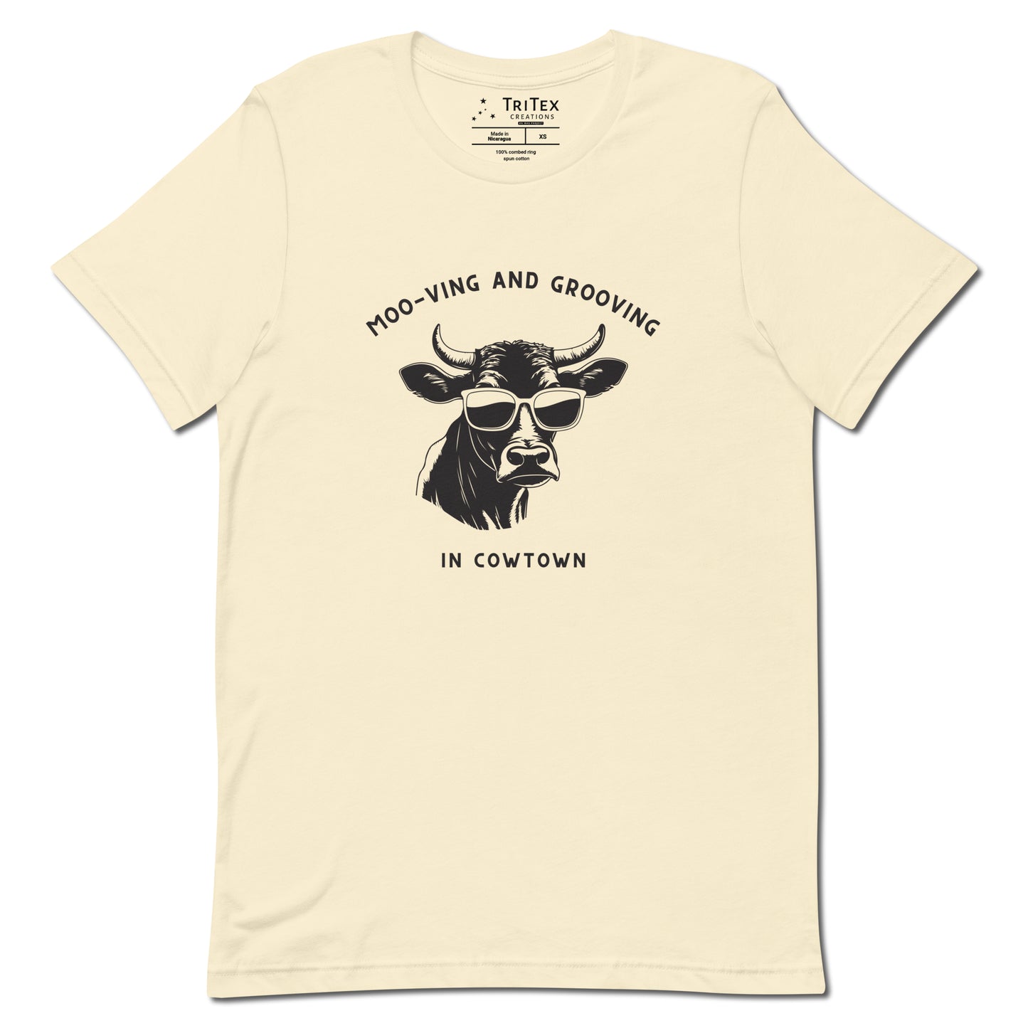 A natural t-shirt featuring an illustration of a cow wearing sunglasses with the the text "Moo-vin' n' groovin' in Cowtown".