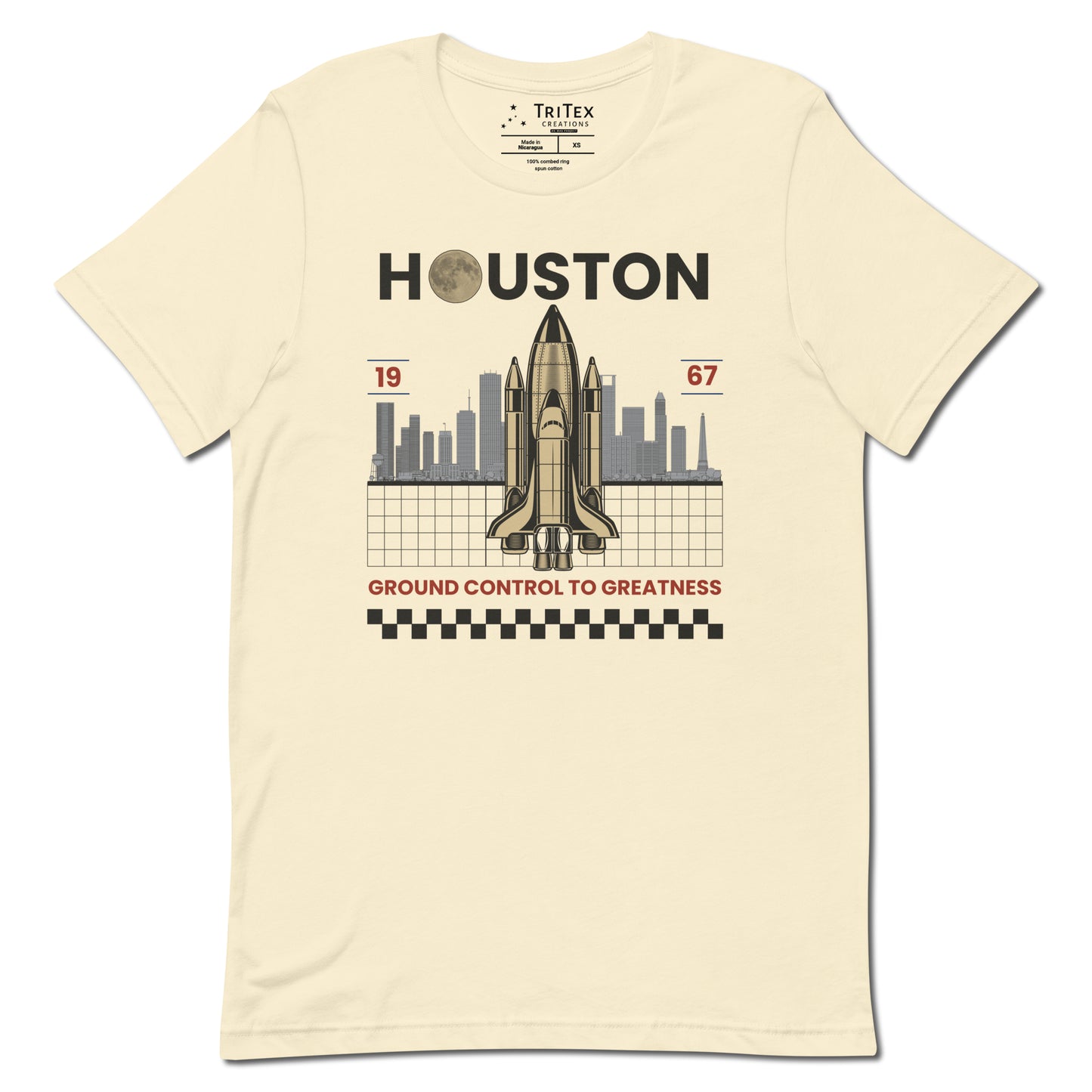 A natural-colored t-shirt featuring a space shuttle in front of the Houston skyline and the text "Houston 1967 Ground control to greatness".