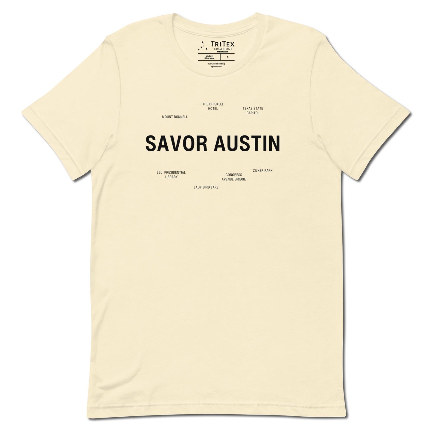 A natural-colored t-shirt which reads "Savor Austin" in big, bold text with smaller text elements naming Austin's landmarks.