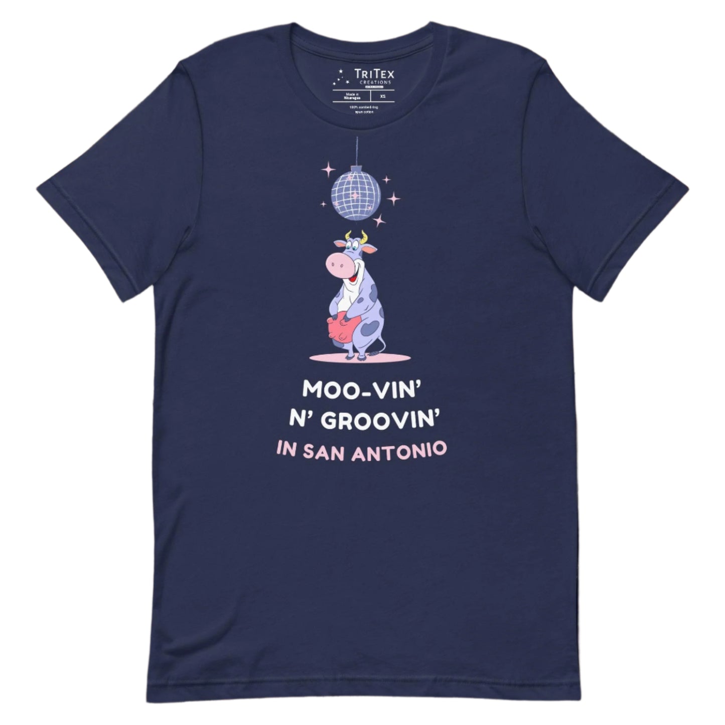 A navy t-shirt with a cartoon cow standing under a sparkling disco ball with the the text "Moo-vin' n' groovin' in San Antonio".