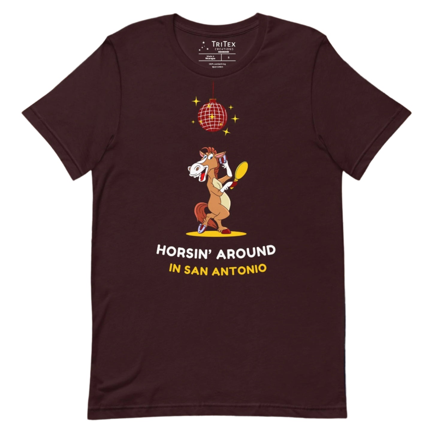 An oxblood black t-shirt featuring an image of a cartoon horse primping under a sparkling disco ball with the words "Horsin' around in San Antonio".