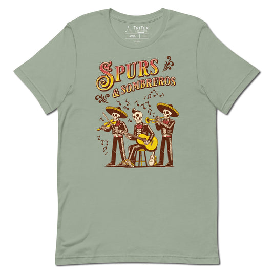 A sage green t-shirt featuring some skeleton mariachis playing music with the words "Spurs & Sombreros".